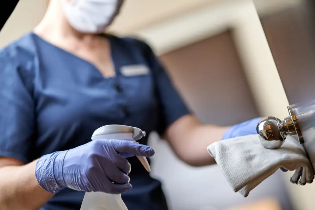 Agent d’entretien en gants désinfectant une surface médicale dans un cabinet à Toulouse