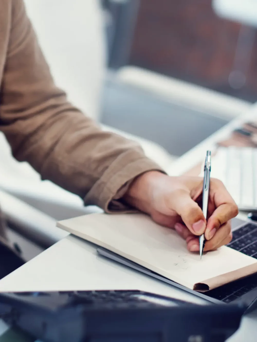 Assistant administratif en entreprise prenant des notes tout en gérant un appel téléphonique – Plus de Services aux Pros à Toulouse