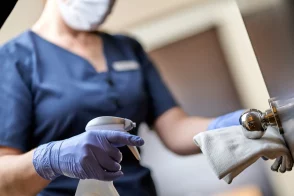 Agent d’entretien en gants désinfectant une surface médicale dans un cabinet à Toulouse